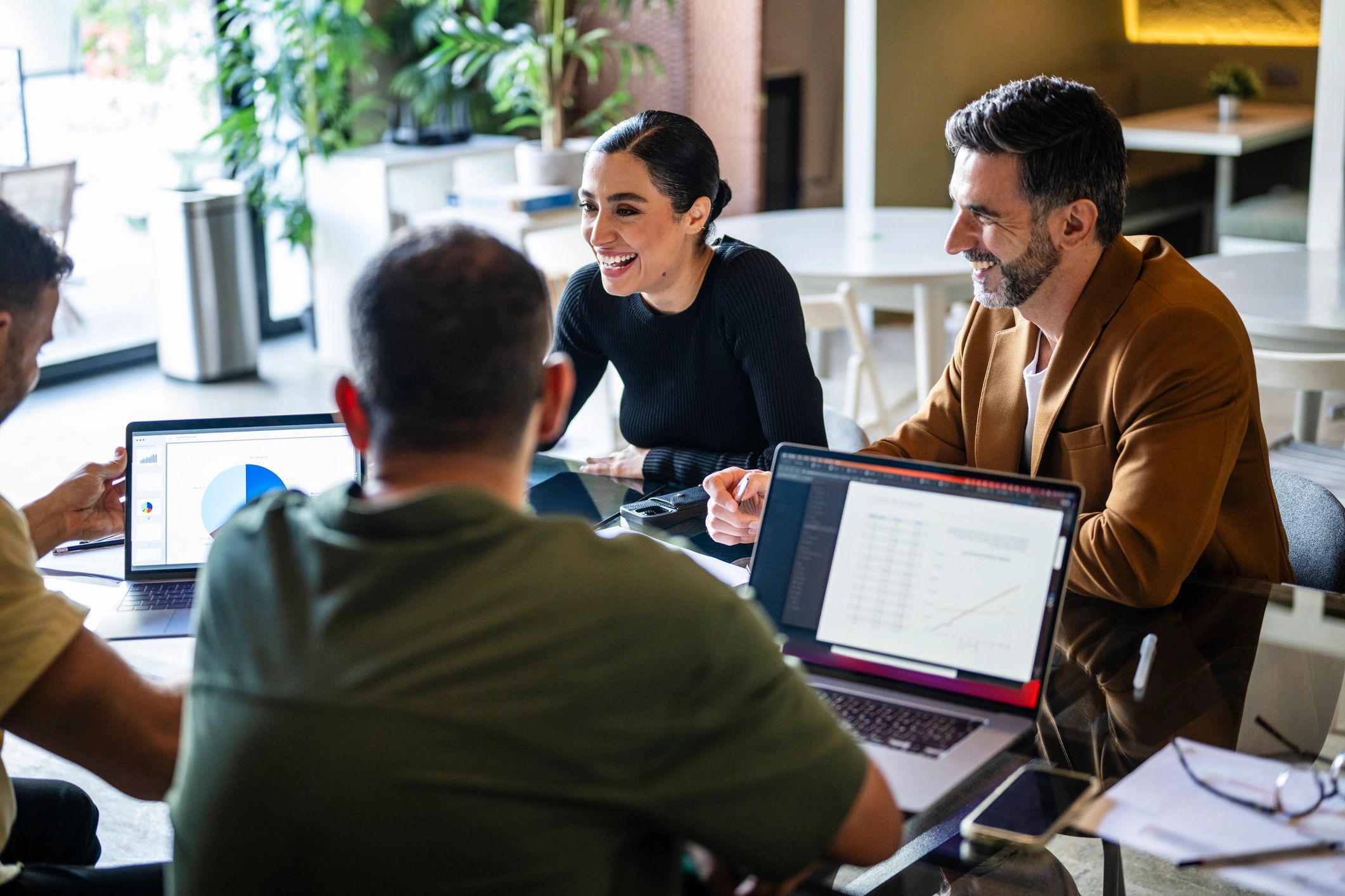 Professionals reviewing ideas together on laptops